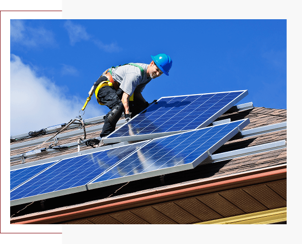 Group 4 (3) A worker in a blue helmet installs solar panels on a rooftop under a clear blue sky.